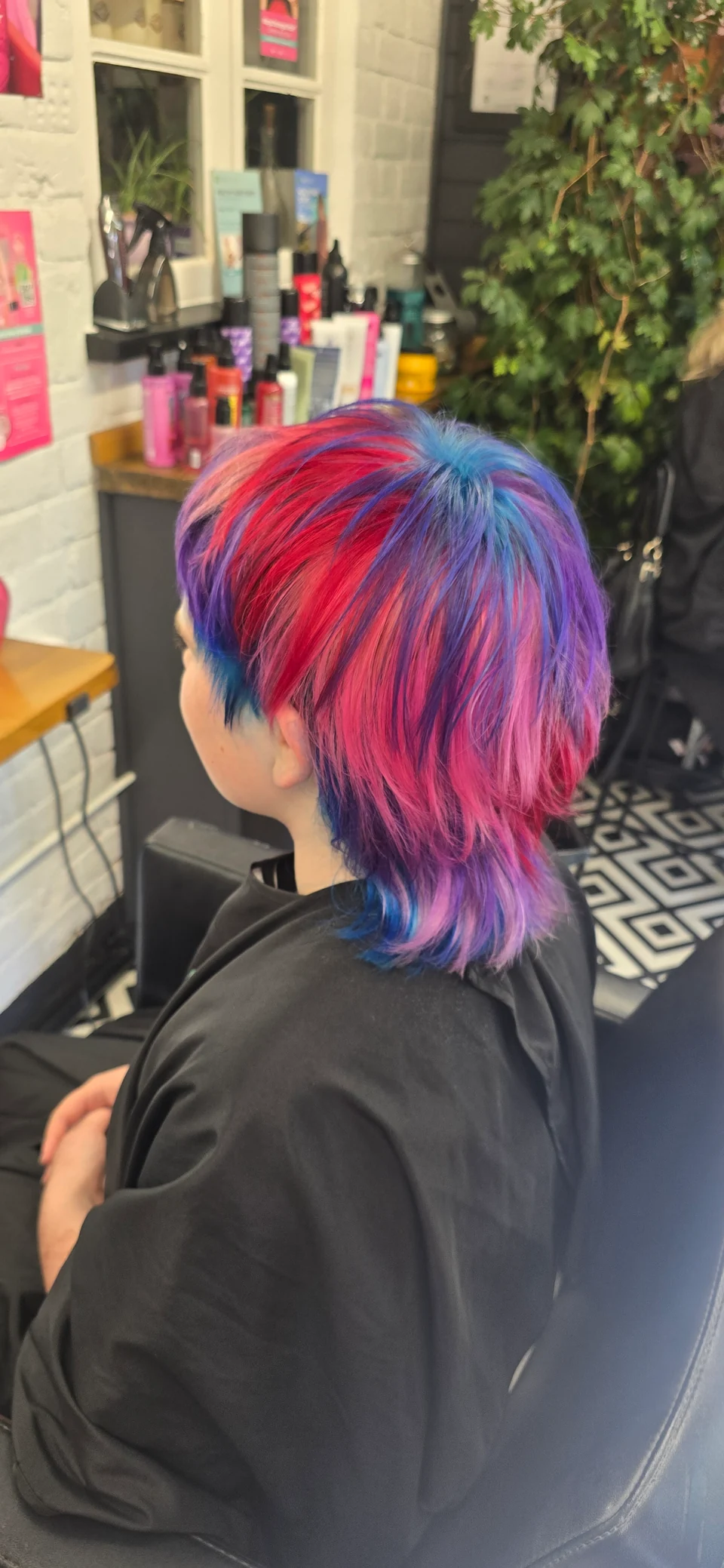 Creative pink, blue and purple hair colour, viewed from behind