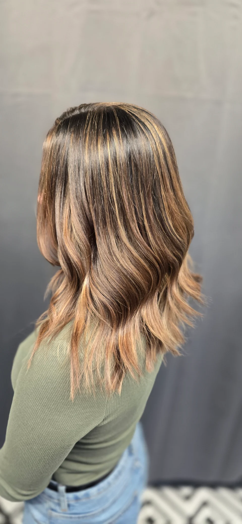 Long bronde hair with soft highlights and loose waves, viewed from behind